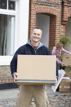 Professional movers preparing an upright piano for safe removal in Westkensington