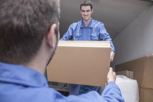 Specialist team handling a grand piano move with protective padding