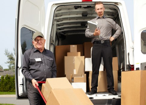 Movers carefully carrying furniture during same day removals in West Kensington