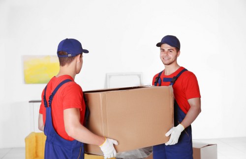 Professional movers dismantling office desks during a Westkensington relocation