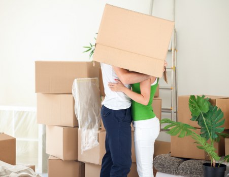 Removal professionals carrying belongings down stairs in a West Kensington flat
